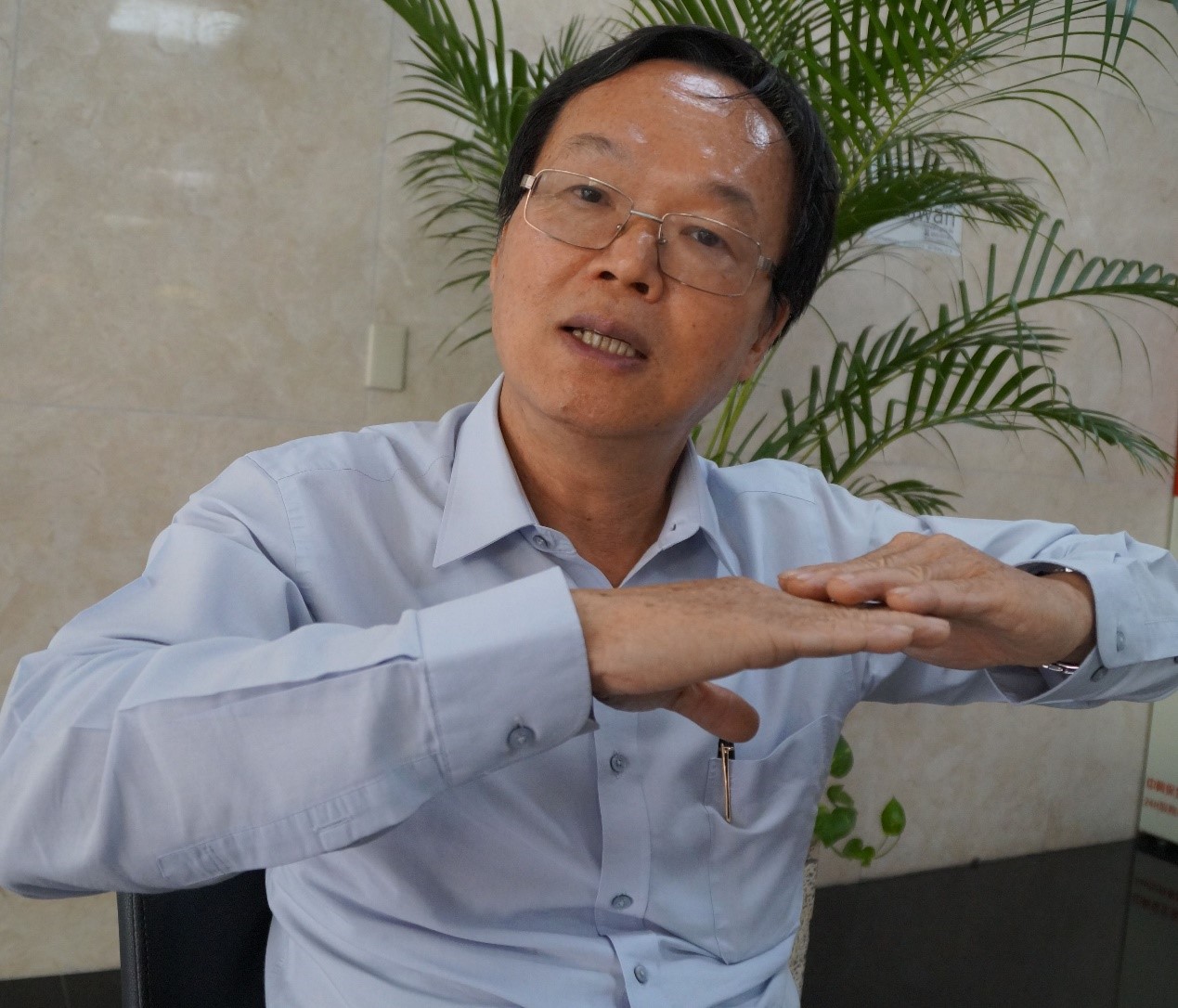 中興大學水土保持學系特聘教授陳樹群利用手勢說明整片滑動型堰塞湖潰壩過程。（圖／李宗祐攝）