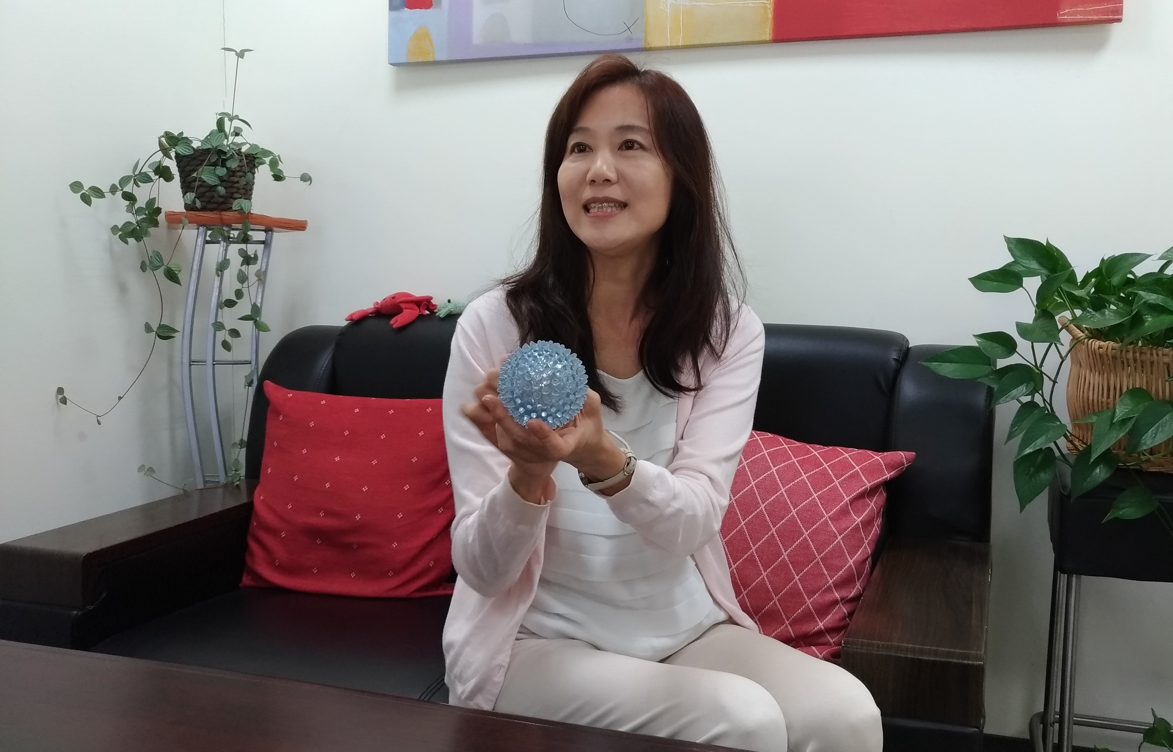 長庚大學新興病毒感染研究中心施信如主任拿著流感病毒模型。（圖／劉馨香攝）